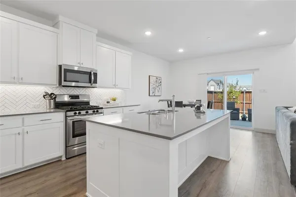 a kitchen with stainless steel appliances granite countertop a stove a sink and a refrigerator