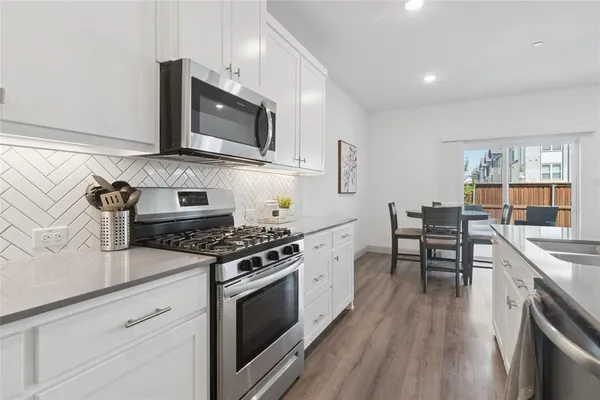 a kitchen with stainless steel appliances a stove a sink and a microwave