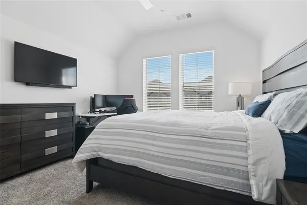 a bedroom with a bed and a flat screen tv