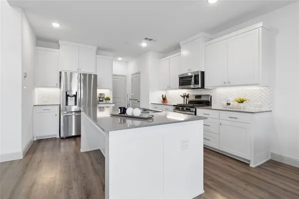 a kitchen with stainless steel appliances a refrigerator stove microwave and cabinets
