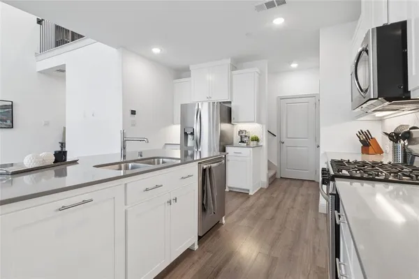a kitchen with white cabinets and stainless steel appliances