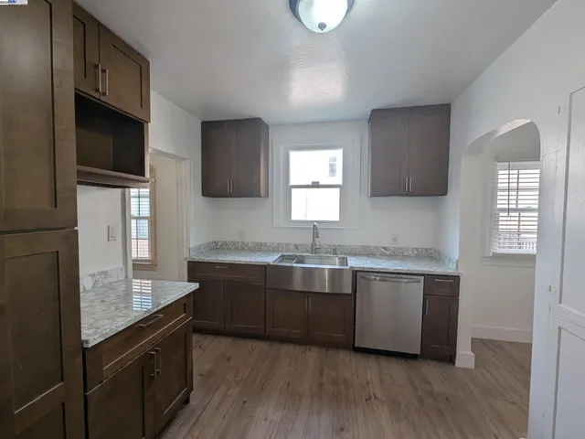a kitchen with granite countertop a sink and cabinets