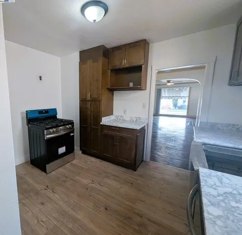 a kitchen with stainless steel appliances kitchen island granite countertop a stove a sink and a refrigerator