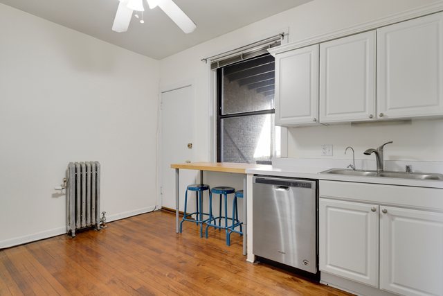 2961 North Halsted Street, Unit 3 Chicago, IL 60657 - Photo 14 of 19 a kitchen with white cabinets and sink
