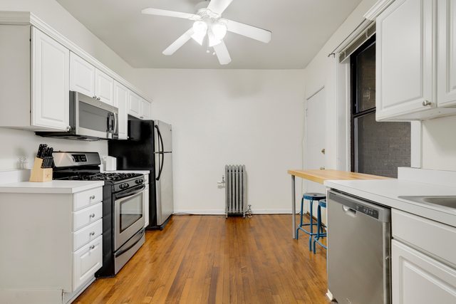2961 North Halsted Street, Unit 3 Chicago, IL 60657 - Photo 16 of 19 a kitchen with stainless steel appliances a white stove top oven a sink dishwasher and a refrigerator with wooden floor