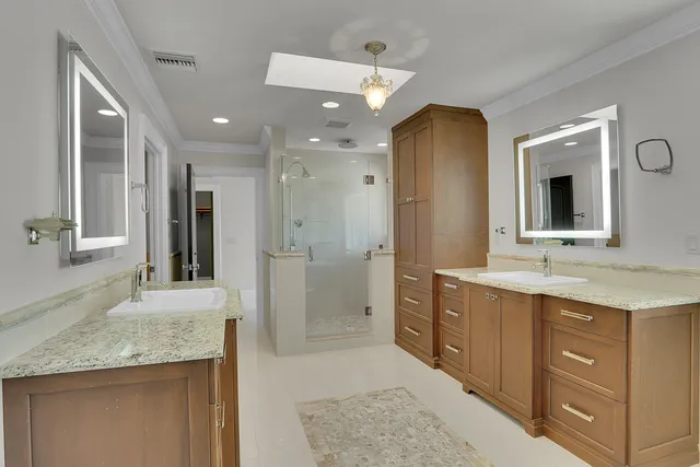 a bathroom with a granite countertop sink mirror and shower