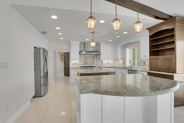 a kitchen with stainless steel appliances granite countertop a sink a oven and a refrigerator