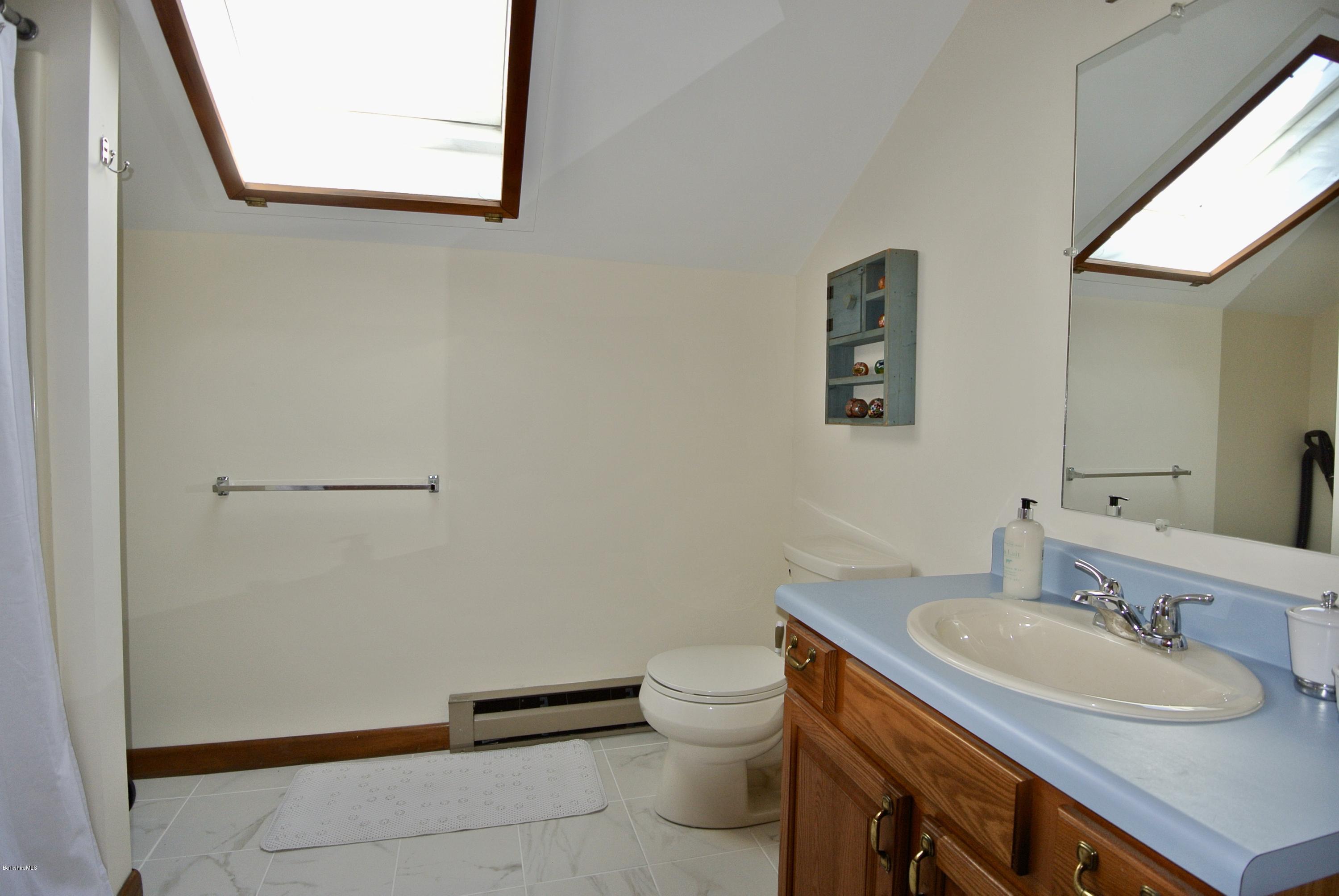 101 Judd Road Otis, MA 01253 - Photo 21 of 29 a bathroom with a sink mirror vanity and toilet