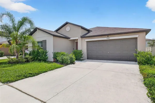 a front view of house with yard and trees
