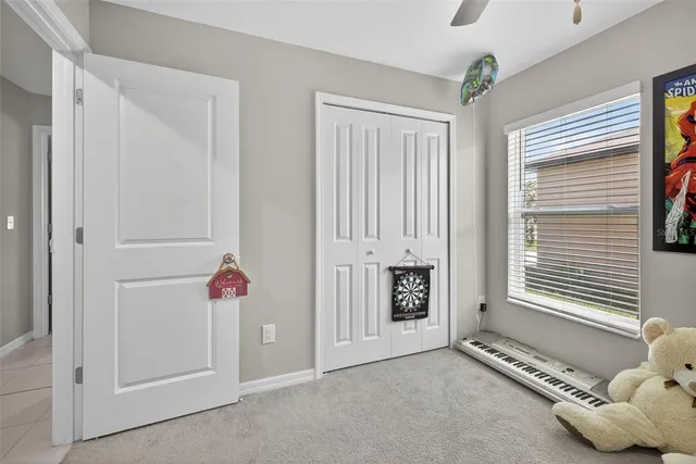 a spacious bedroom with a bed and a ceiling fan