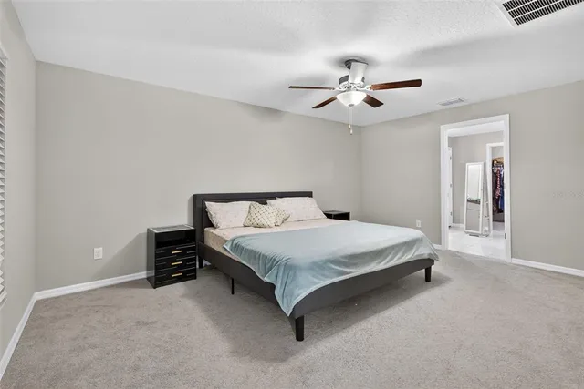 a bedroom with a bed and a ceiling fan