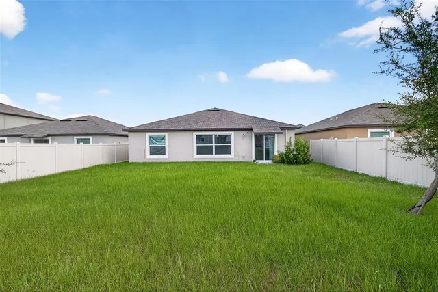 a front view of a house with a yard and trees