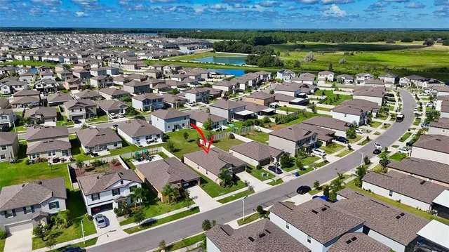an aerial view of a house with a garden and lake view