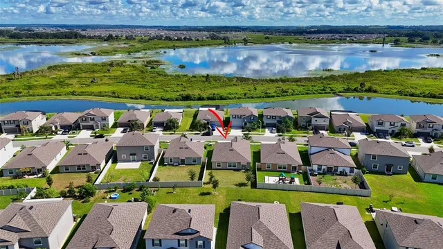 an aerial view of residential houses with outdoor space and lake view