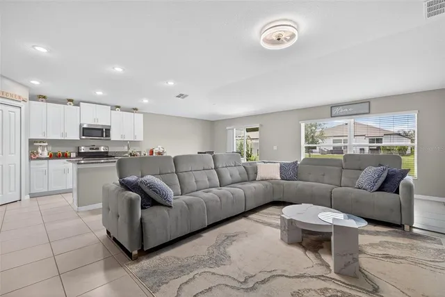 a living room with furniture and a view of kitchen
