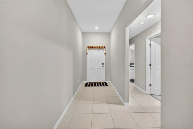 a view of a hallway with wooden floor and a bathroom