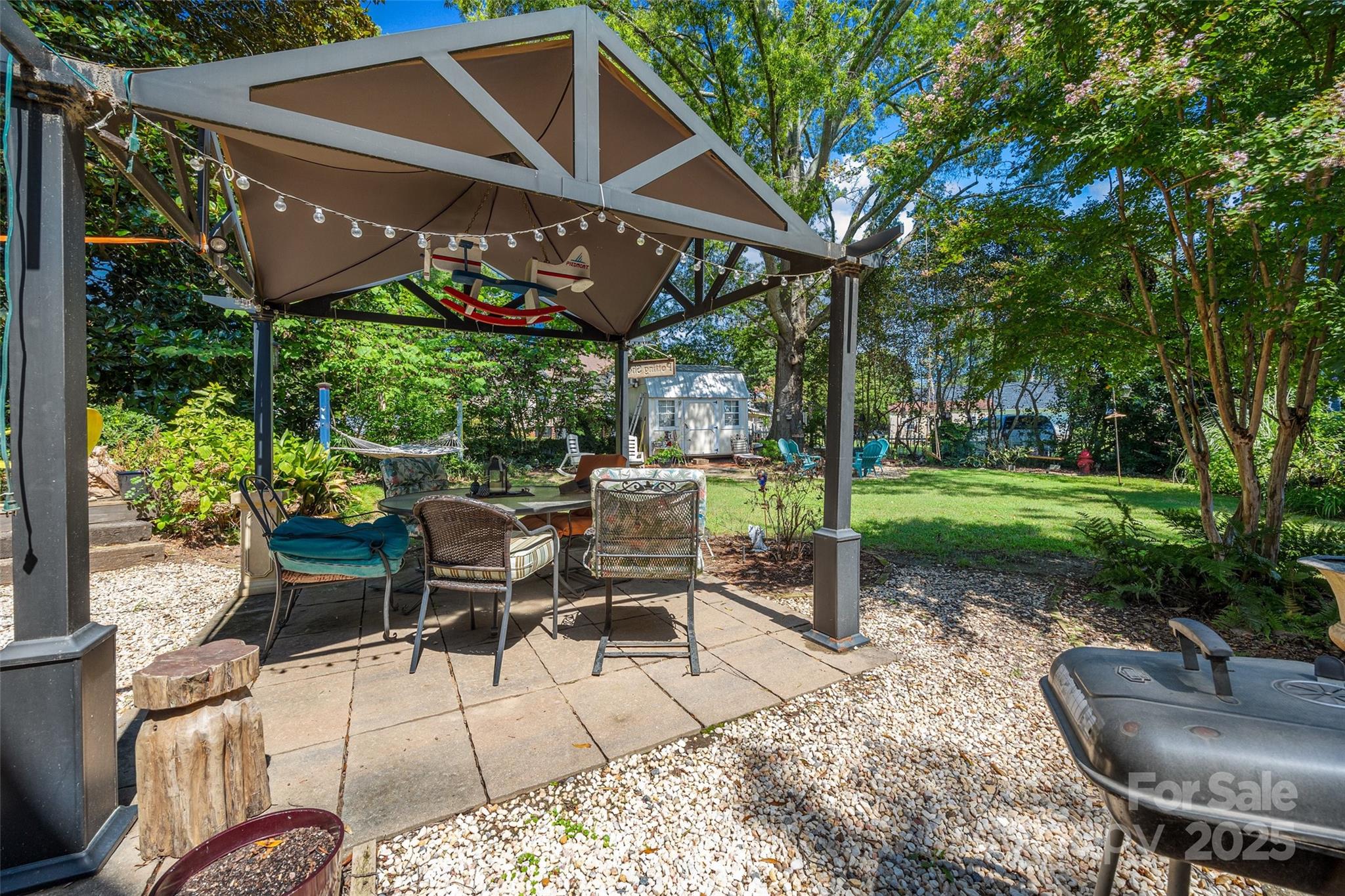205 East Jefferson Street York, SC 29745 - Photo 23 of 35 a view of a patio with table and chairs with wooden fence and plants