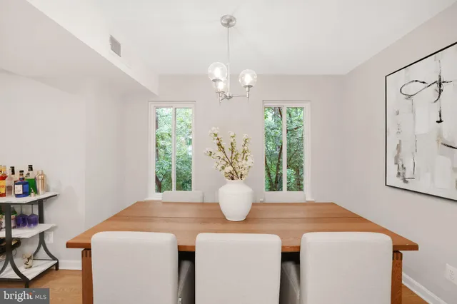 a dining room with chandelier and wooden floor