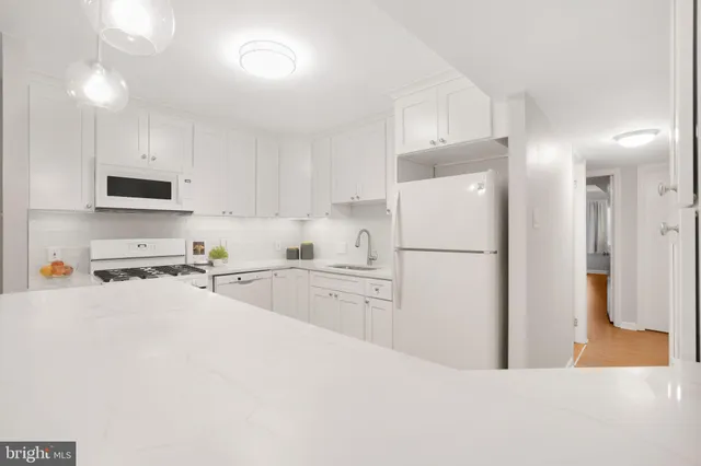 a kitchen with white cabinets and refrigerator