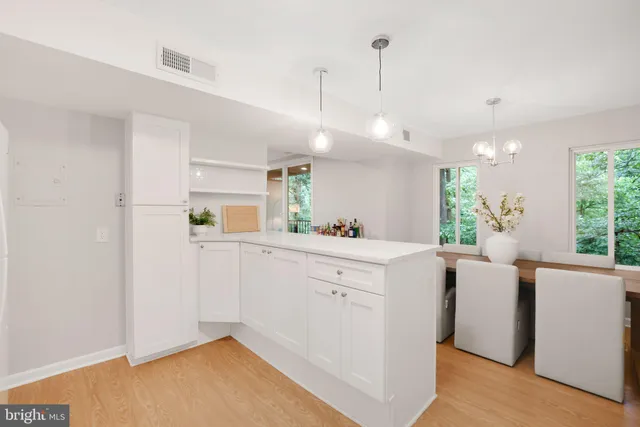 a view of a kitchen with kitchen island a sink wooden floor and window