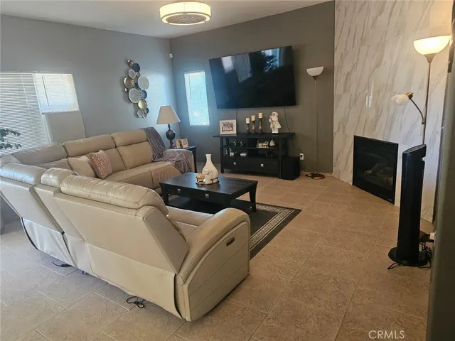 a living room with furniture a flat screen tv and a fireplace