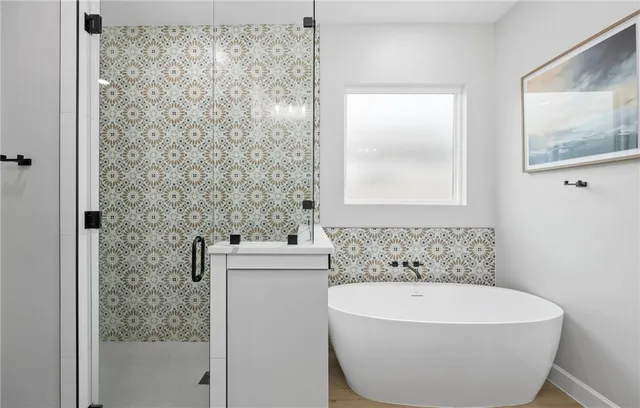 a white bath tub sitting next to a white sink and vanity
