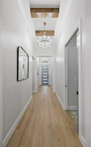 a view of a hallway with wooden floor and a window