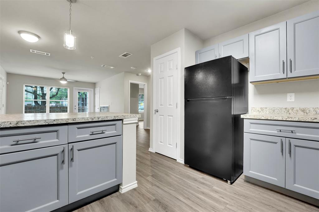 a kitchen with a refrigerator and white cabinets