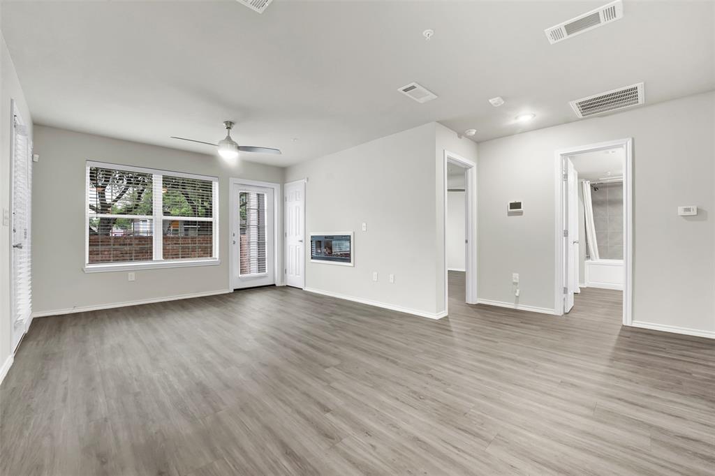 6108 Abrams Road, Unit 201 Dallas, TX 75231 - Photo 2 of 19 an empty room with wooden floor and windows