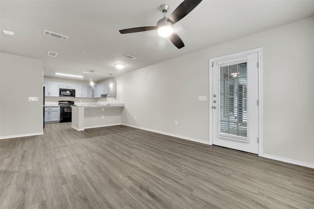 6108 Abrams Road, Unit 201 Dallas, TX 75231 - Photo 3 of 19 a view of a kitchen with a stove wooden cabinets and wooden floor