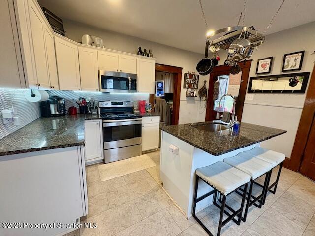1200 Watson Street Scranton, PA 18504 - Photo 12 of 49 a kitchen with stainless steel appliances granite countertop a sink dishwasher a microwave oven a stove with granite countertop cabinets and wooden floor
