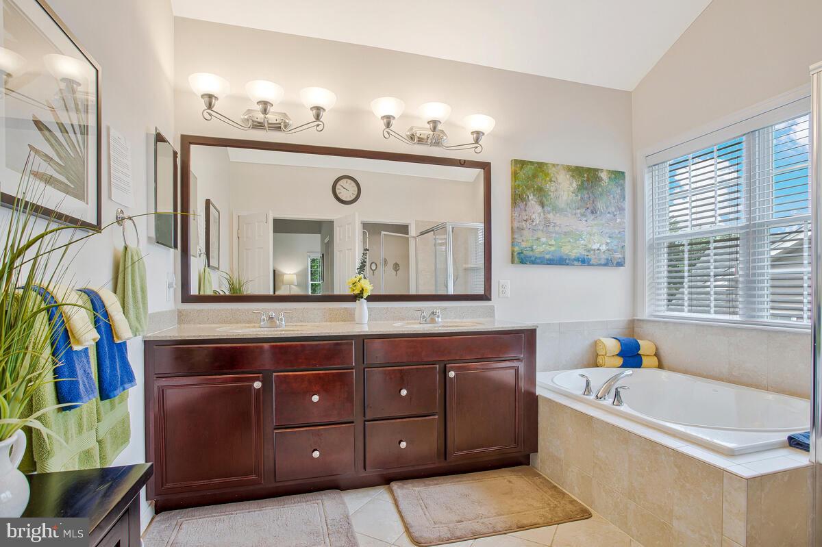 4006 Bridle Ridge Road Upper Marlboro, MD 20772 - Photo 41 of 45 a bathroom with a tub a sink and a large mirror