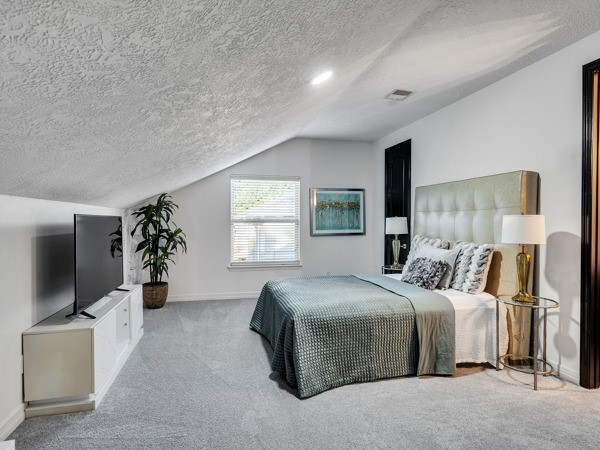 2523 Watts Street Houston, TX 77030 - Photo 39 of 45 a bedroom with a large bed and a flat tv screen on dresser