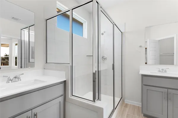 a bathroom with a shower sink and mirror