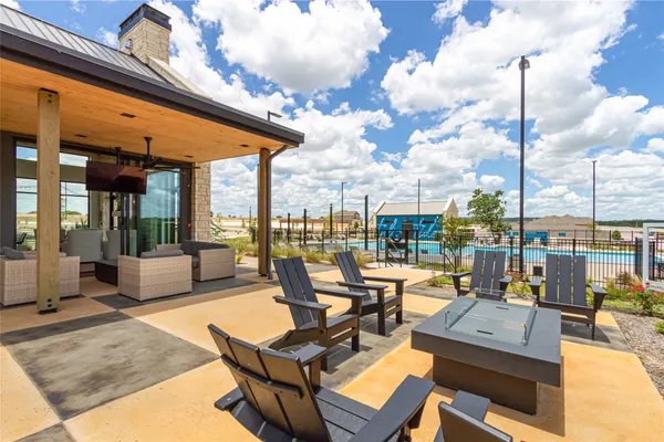 an aerial view of a swimming pool with outdoor seating