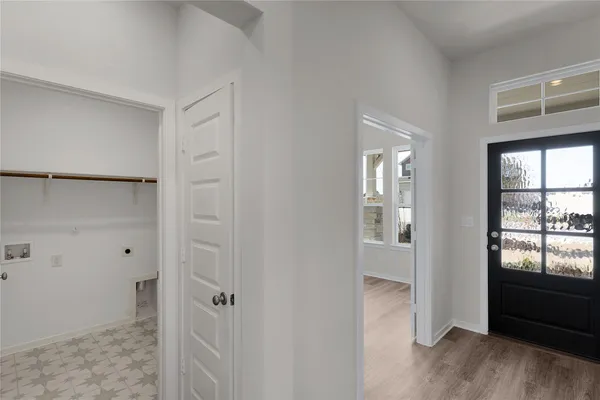 a view of a hallway with wooden floor and a bathroom