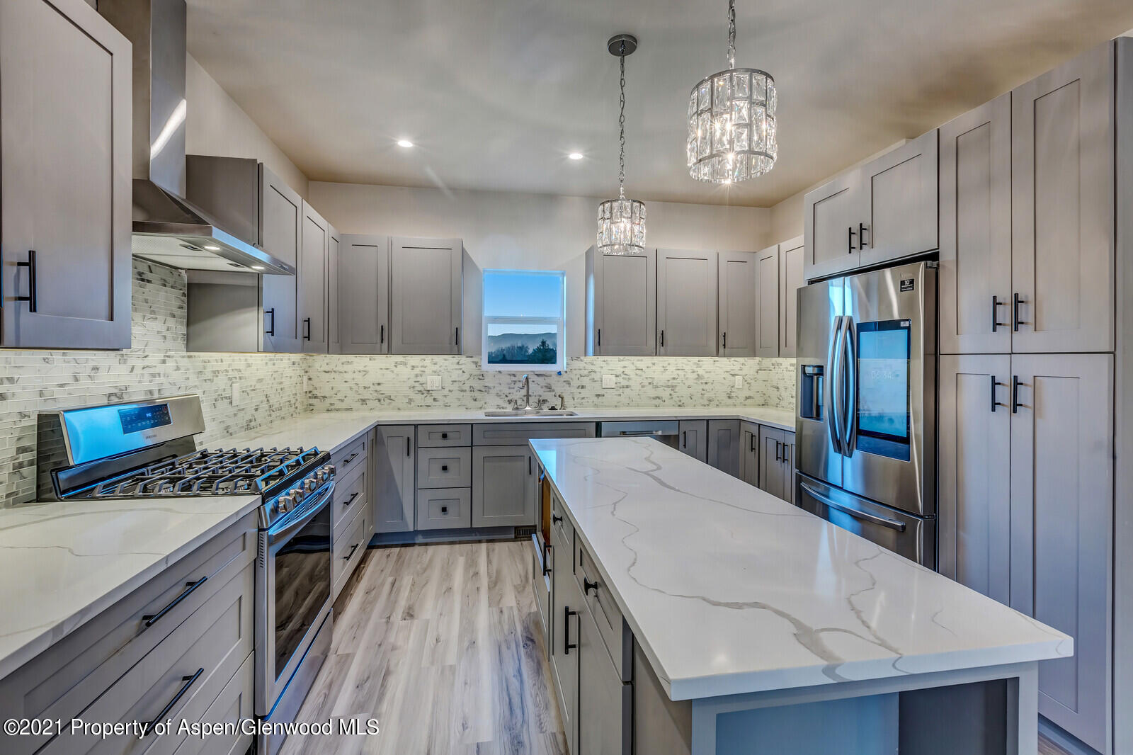 a kitchen with granite countertop a sink a counter space stainless steel appliances and cabinets