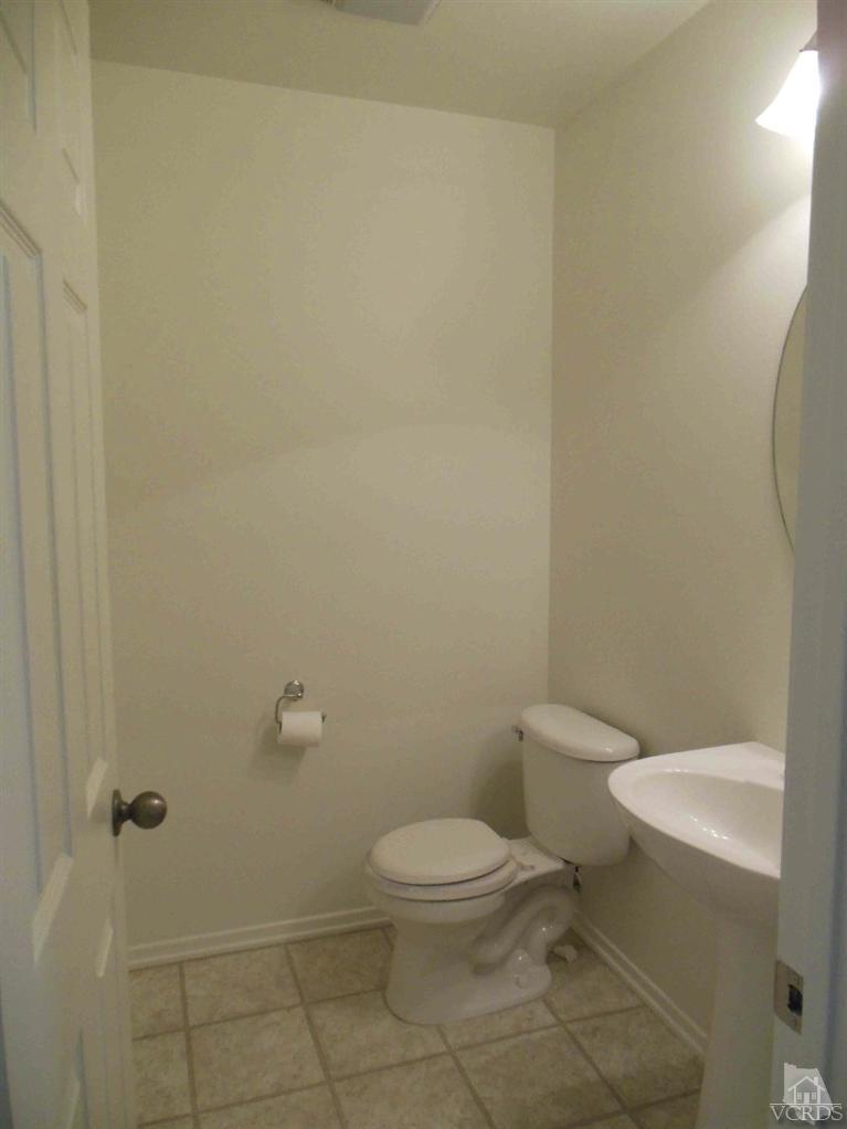 1146 Azalea Way Simi Valley, CA 93065 - Photo 17 of 22 a white toilet sitting next to a white sink and vanity
