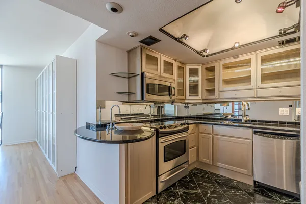 a kitchen with wooden cabinets and stainless steel appliances