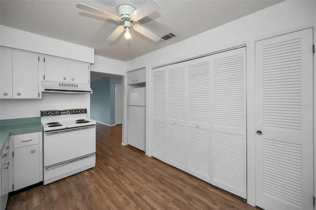 a view of empty room with wooden floor and closet