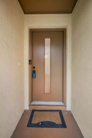 a view of empty room with wooden floor and kitchen
