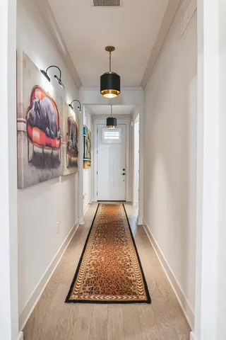 hallway view with wooden floor and dining table