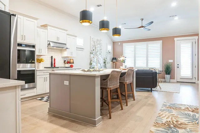 a room with stainless steel appliances kitchen island granite countertop a sink and cabinets
