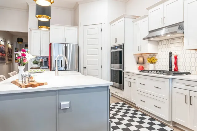 a kitchen with stainless steel appliances kitchen island granite countertop a refrigerator and a sink