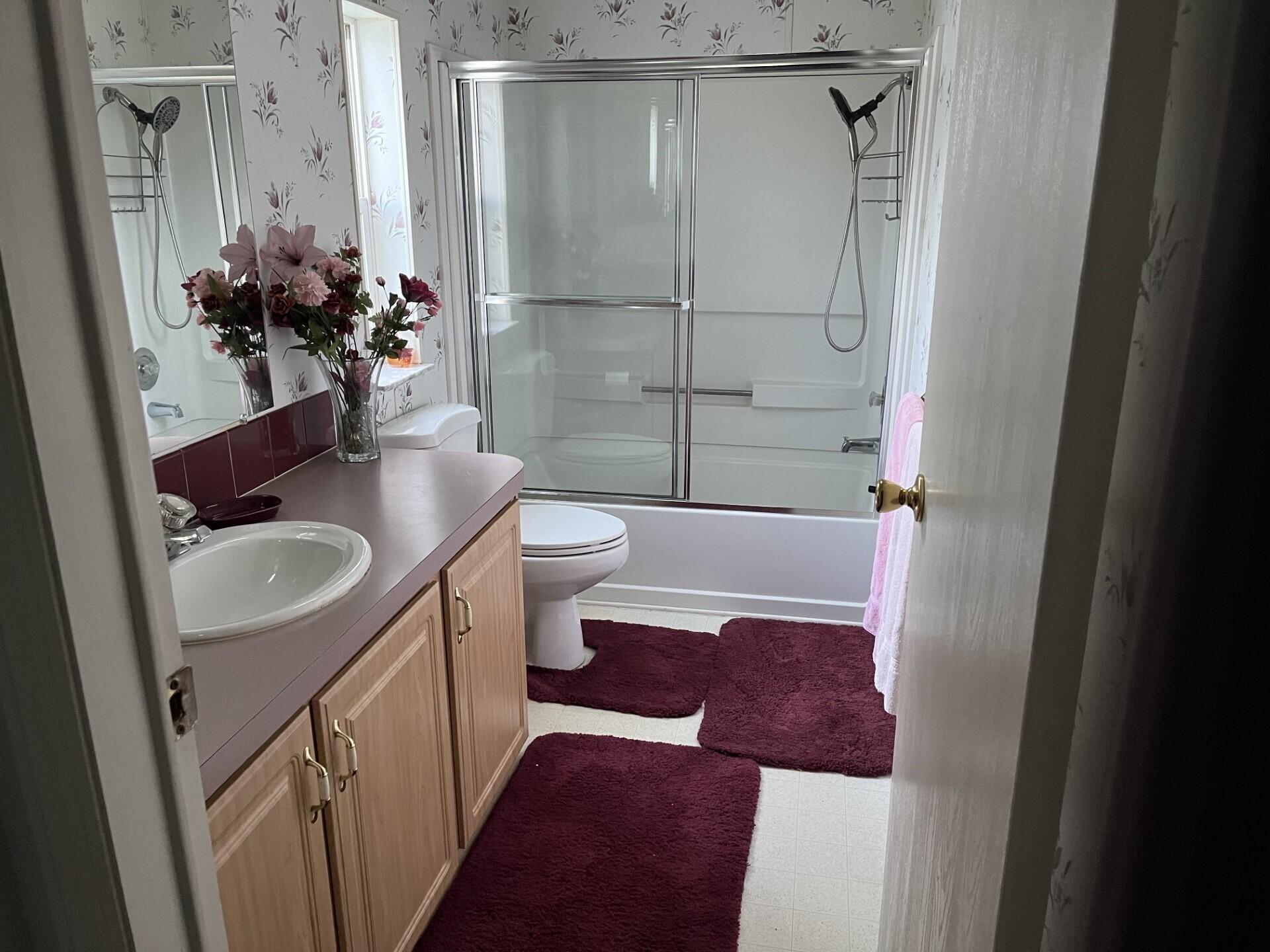 6325 Southeast Colonial Drive Stuart, FL 34997 - Photo 4 of 8 a bathroom with a sink a toilet and shower