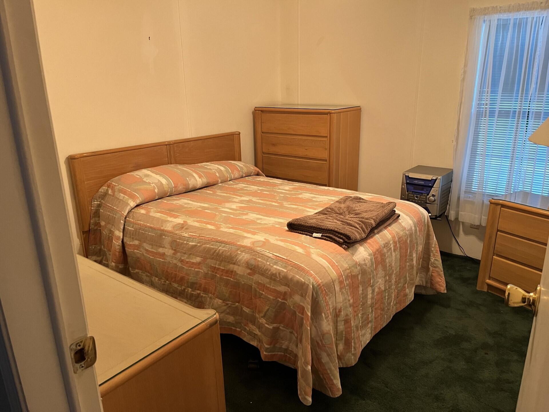 6325 Southeast Colonial Drive Stuart, FL 34997 - Photo 7 of 8 a bed sitting in a bedroom next to a window