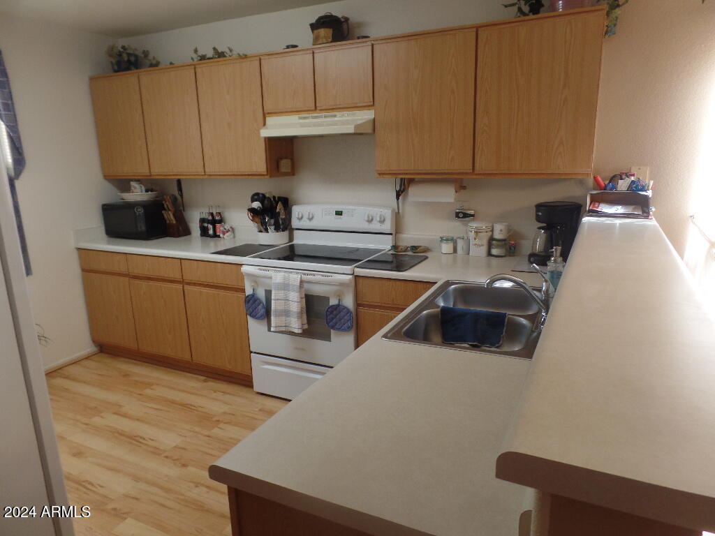 1873 West Renaissance Avenue Apache Junction, AZ 85120 - Photo 8 of 18 a kitchen with stainless steel appliances granite countertop a sink a stove and a refrigerator