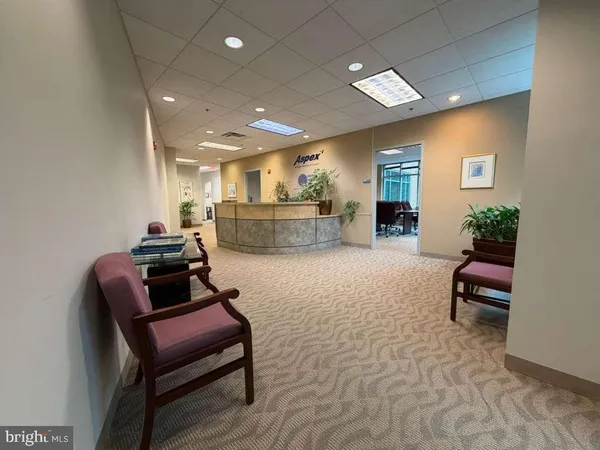 a view of a workspace with furniture and a window