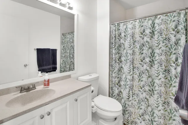 a bathroom with a granite countertop sink a toilet and a mirror