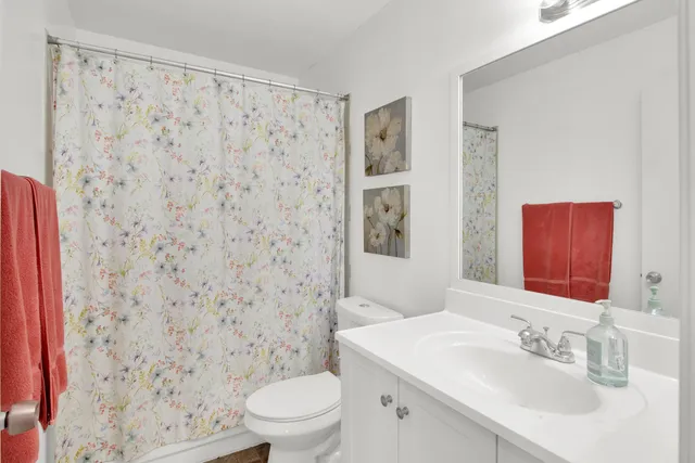 a bathroom with a sink a toilet and shower curtain